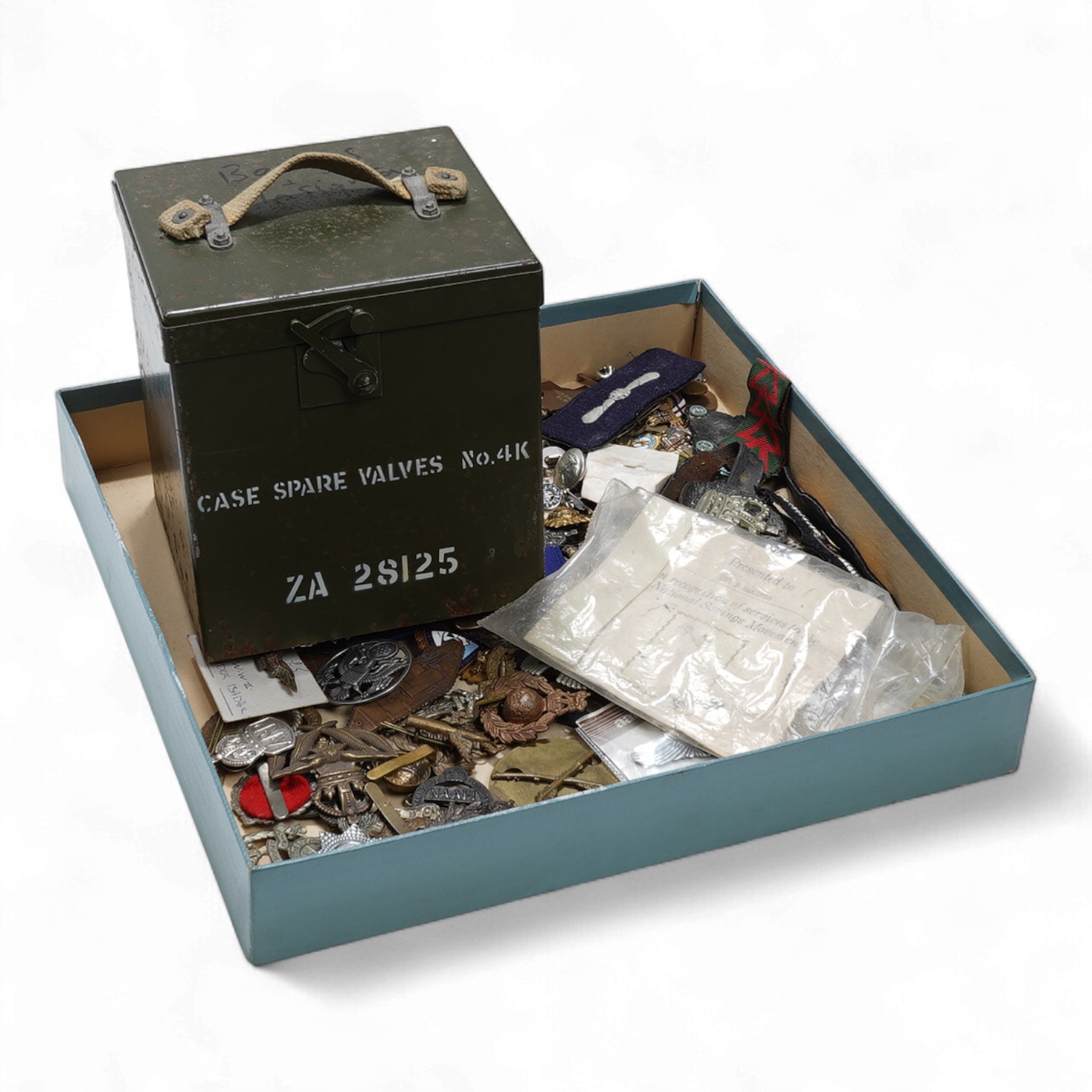 A collection of primarily 20th century military badges, lapel badges, shoulder titles, and other related ephemera, including seventeen military cap badges, cloth badges, ARP badges, etc., together with a military tin box